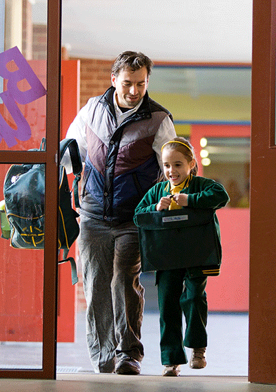 Parent and child walking into school.